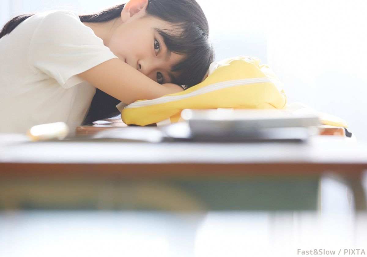 机に伏せる少女