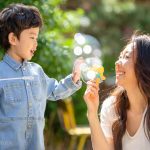 シャボン玉で遊ぶ男の子と女性