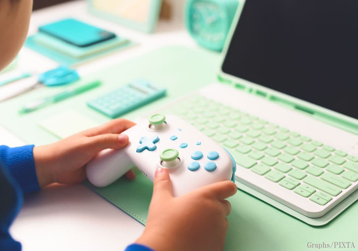ゲームコントローラーと子どもの手