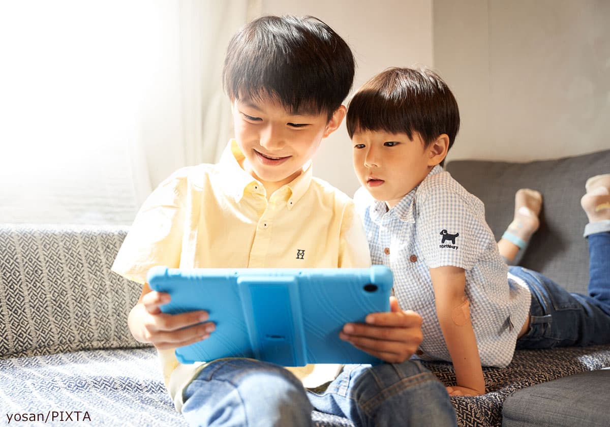 タブレットに熱中する子ども