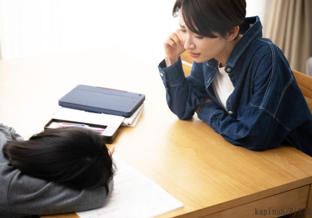 伏せる子どもを見つめる母親