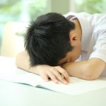 頭を突っ伏す中学生男子