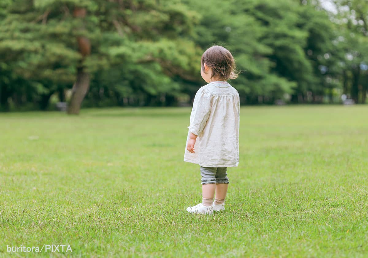 公園で遊ぶ3歳くらいの子どもの後ろ姿