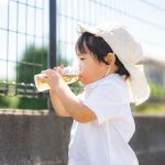 水筒で飲み物を飲む2歳の男の子