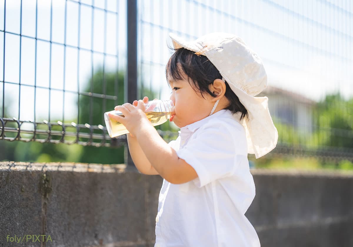 水筒で飲み物を飲む2歳の男の子