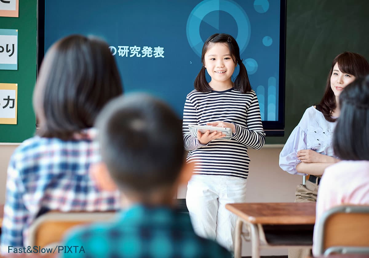 他の子の前で発表する小学生の子