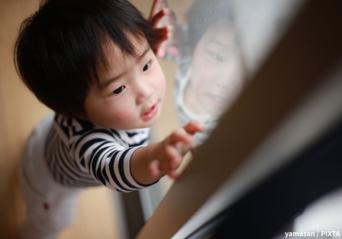 ベランダの鍵を開けようとする幼児