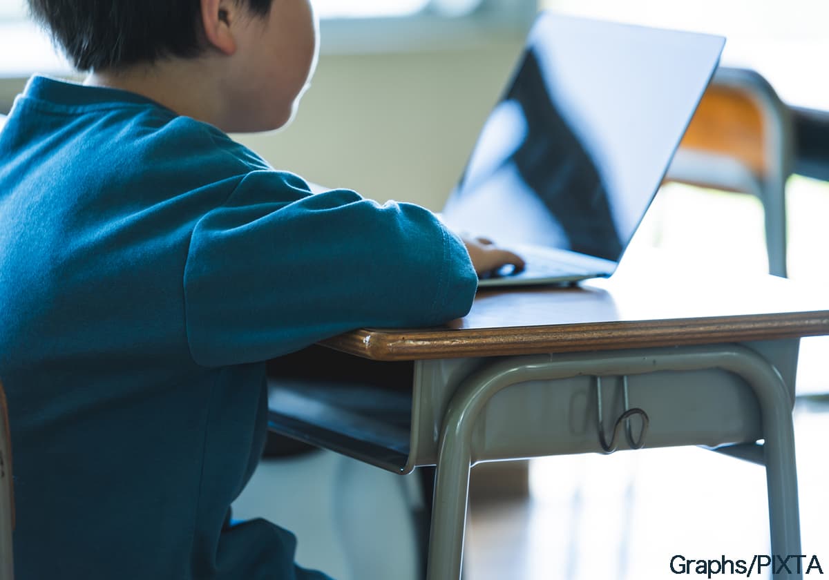 教室で机に座る小学生の子
