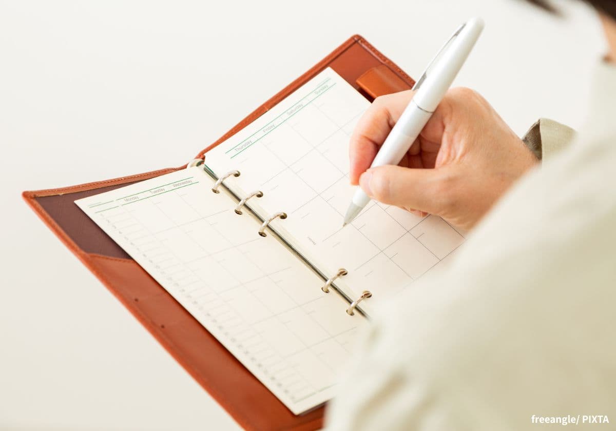 手帳に書き込むママ