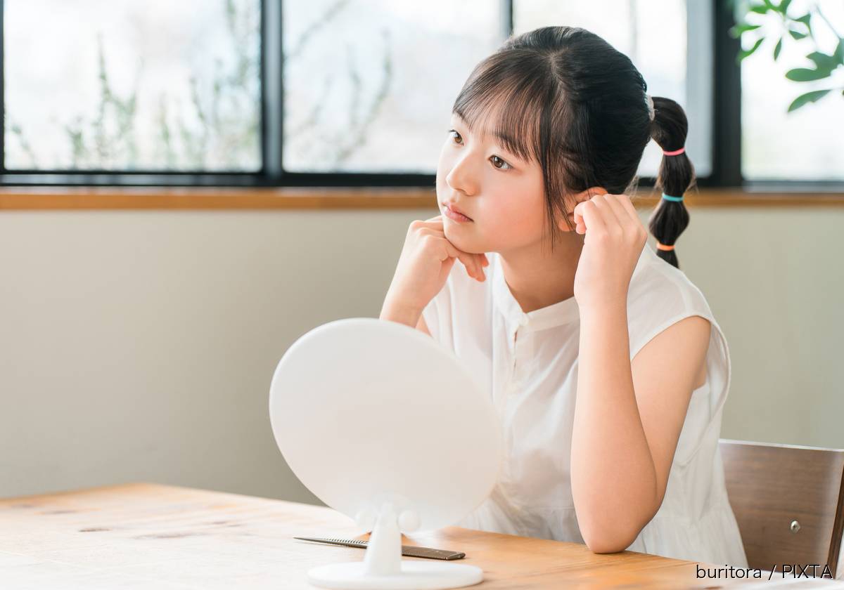 鏡を気にする小学生の女の子